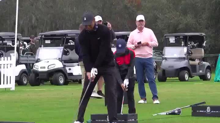 Con trai phát bóng cùng Tiger Woods